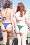 Garotas curvilíneas de biquíni caminhando na praia
